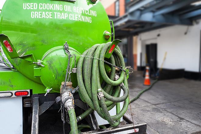 a technician pumping a grease trap in a commercial building in Wood River